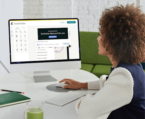 Image of person in sitting at desk looking at their computer monitor where they are using Mailchimp’s power and intuitive Email Builder feature to create personalized email campaigns to marketing their business to their customers.